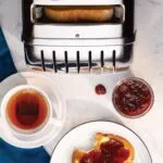 Dualit Da0144 6 Slice Vario Toaster in Polished Stainless Steel with Toast Tea and Jam on a Table
