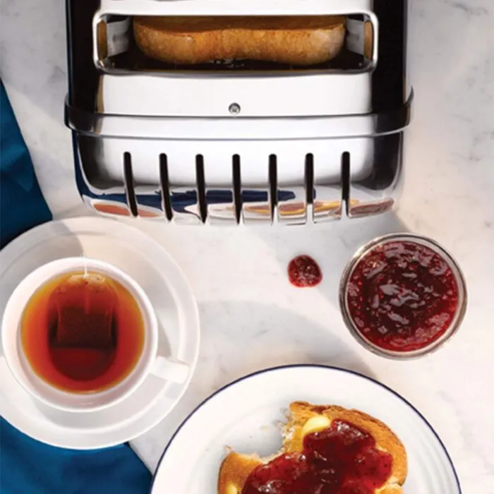 Dualit Da0144 6 Slice Vario Toaster in Polished Stainless Steel with Toast Tea and Jam on a Table